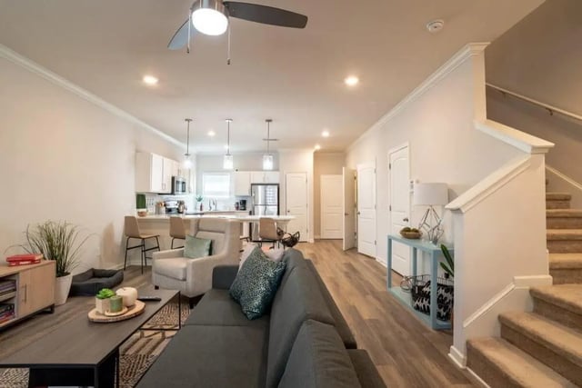Sofa armchair kitchen island staircase living room at The Collective At Clemson in Clemson Student Accommodation