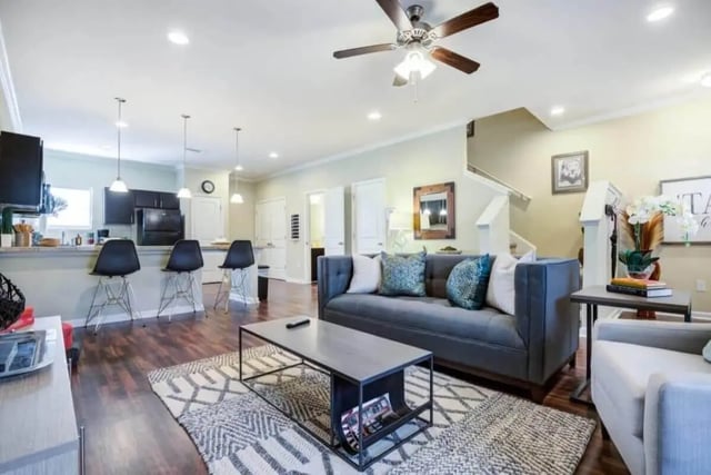 Gray sofa coffee table patterned rug living room at The Collective At Clemson in Clemson Student Accommodation