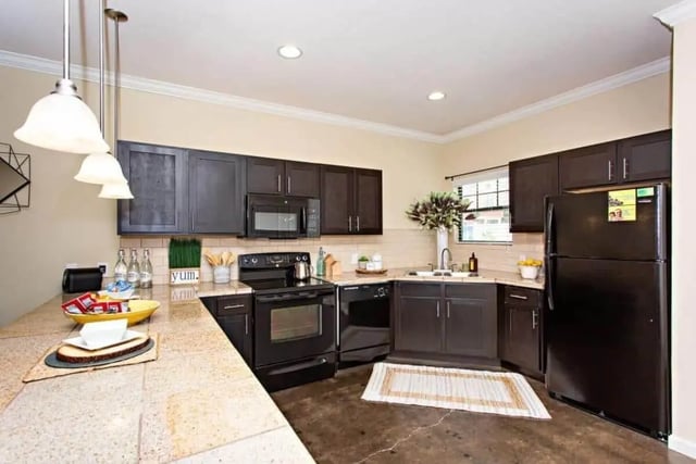 Dark cabinets microwave oven refrigerator kitchen at The Collective At Clemson in Clemson Student Accommodation