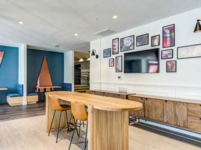 Large wooden table chairs wall art living room at Wertland Square in Charlottesville Student Accommodation