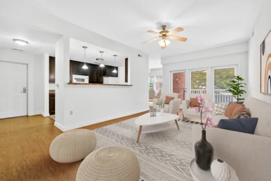 Couch chairs coffee table two ottomans kitchen living room at Wertland Square in Charlottesville Student Accommodation