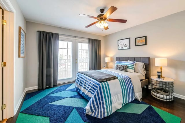 Bed with blue striped bedding ceiling fan bedroom at The Commons at Knoxville in Knoxville Student Accommodation
