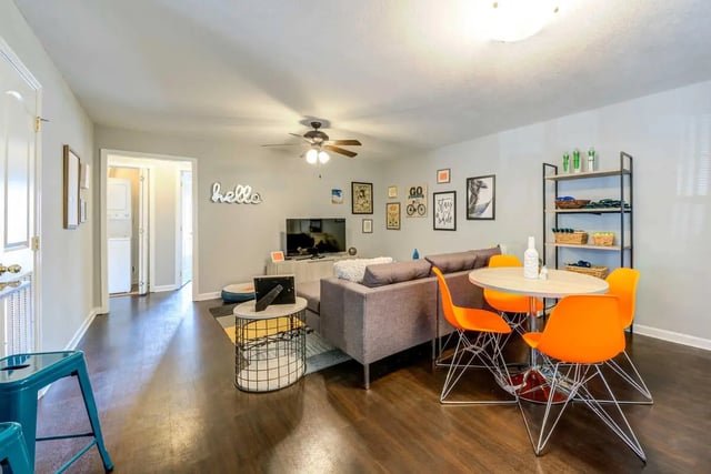 Gray sofa orange chairs round table living room at The Commons at Knoxville in Knoxville Student Accommodation