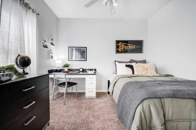 Bed desk dresser and globe bedroom at The Lodge on the Trail Apartments in West Lafayette Student Accommodation