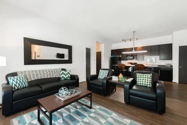 Sofa chairs coffee table kitchen living room at Miami Preserve in Oxford Student Accommodation