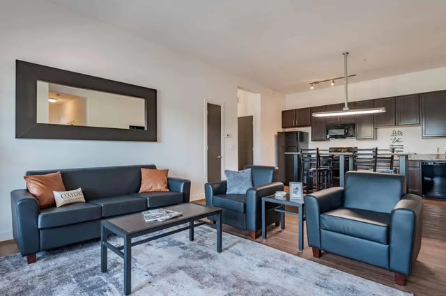 Black leather sofa two armchairs coffee table living room at Miami Preserve in Oxford Student Accommodation