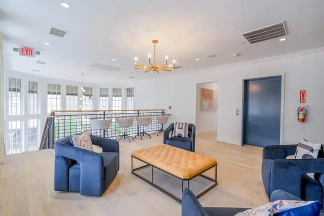 Blue chairs orange ottoman bar stools living room at The Collective At Lubbock in Lubbock Student Accommodation