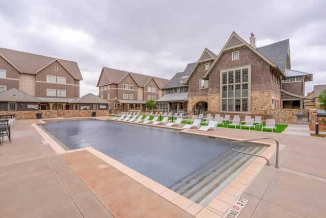 Swimming pool with lounge chairs and buildings exterior at The Collective At Lubbock in Lubbock Student Accommodation