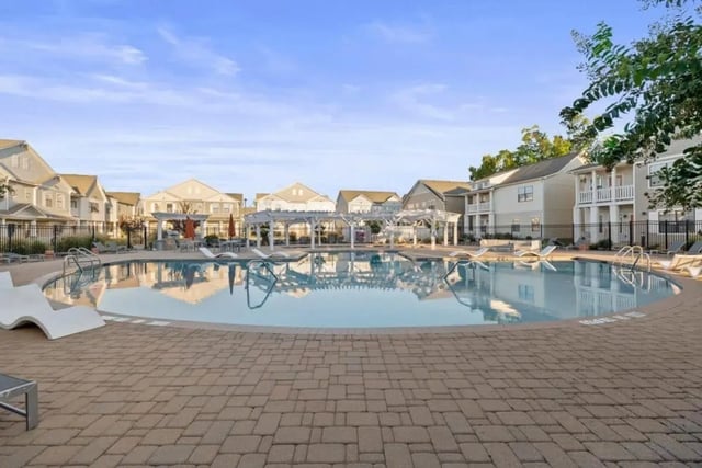 Pool with lounge chairs and buildings playing area at The Collective At Norman in Norman Student Accommodation