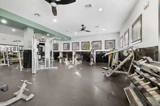Gym equipment with weight racks and dumbbells playing area at The Collective At Norman in Norman Student Accommodation