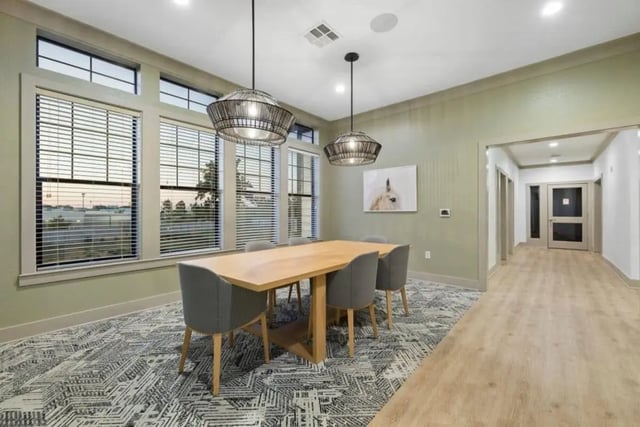 Table chairs hanging lights patterned carpet dining area at The Collective At Norman in Norman Student Accommodation