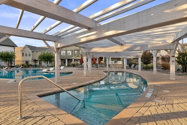 Pool with lounge chairs and pergola outdoor living area at The Collective At Norman in Norman Student Accommodation
