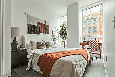 Bed with orange throw desk and chair bedroom at The Archive in New Haven Student Accommodation