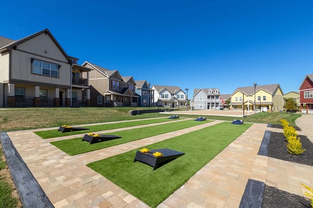 Cornhole boards on green lawn by apartments exterior at The Collective at Columbia in Columbia Student Accommodation