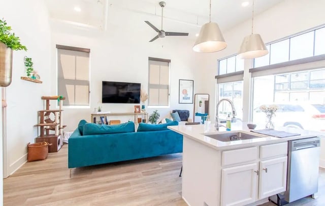 Teal sofa and kitchen island living room at Midtown Auburn in Auburn Student Accommodation