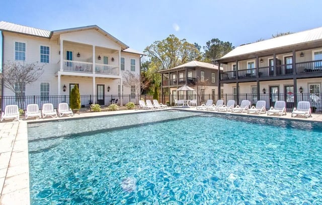 Pool with lounge chairs and apartments exterior at Midtown Auburn in Auburn Student Accommodation