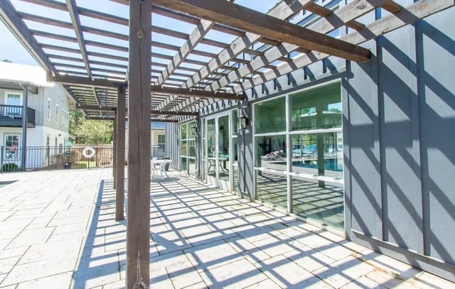 Pergola over paved patio with white table Exterior at Midtown Auburn in Auburn Student Accommodation