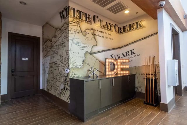 Map mural lighted letters and pool cues hallway at The Waverly in Newark Student Accommodation