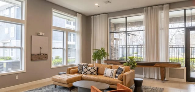 Brown sectional sofa coffee table and shuffleboard table living room at The Connection at Lawrence in Lawrence Student Accommodation