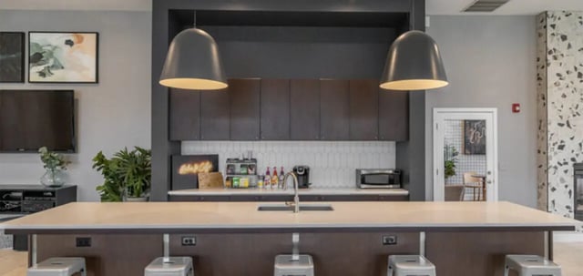 Island counter with stools and kitchen cabinets kitchen at The Connection at Lawrence in Lawrence Student Accommodation