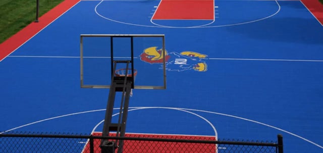 Blue basketball court with KU logo and hoop playing area at The Connection at Lawrence in Lawrence Student Accommodation