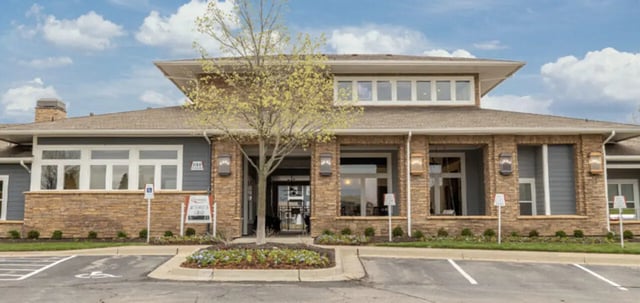 Brick and gray building with parking spaces exterior at The Connection at Lawrence in Lawrence Student Accommodation