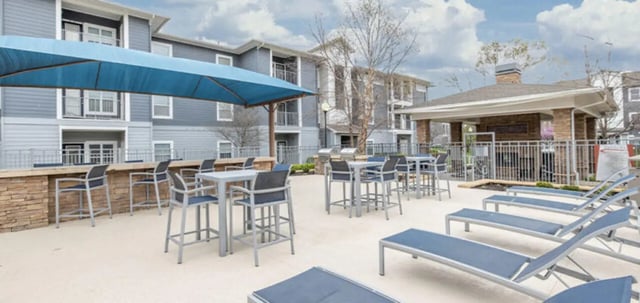 Bar stools tables lounge chairs exterior at The Connection at Lawrence in Lawrence Student Accommodation