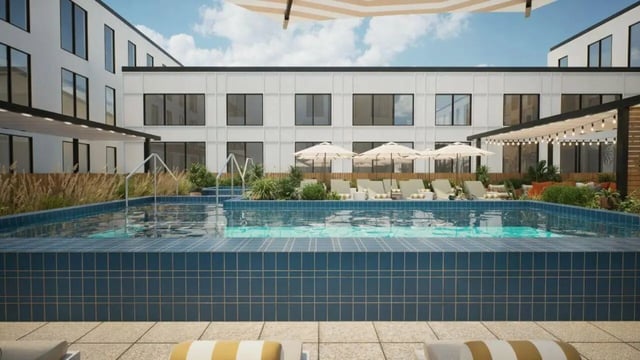 Pool with lounge chairs and umbrellas exterior at Proxi Lawrence Apartments in Lawrence Student Accommodation