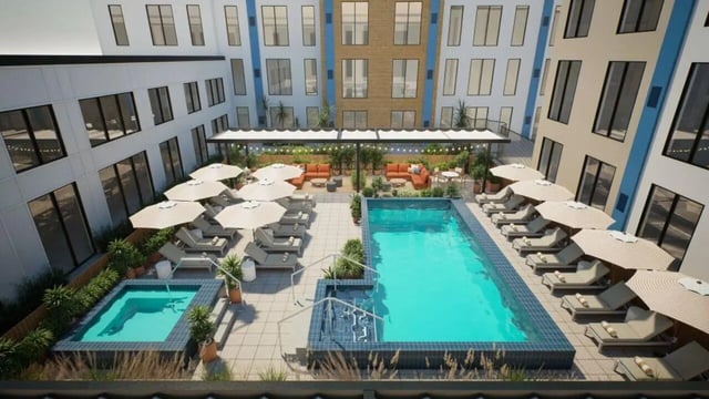 Pool lounge chairs cabanas and seating area courtyard at Proxi Lawrence Apartments in Lawrence Student Accommodation