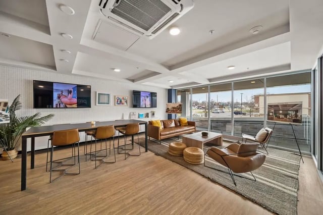 Lounge with sofas table chairs televisions living room at Proxi Lawrence Apartments in Lawrence Student Accommodation