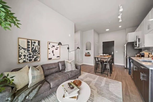 Gray sectional sofa with art and bar seating living room at Proxi Lawrence Apartments in Lawrence Student Accommodation