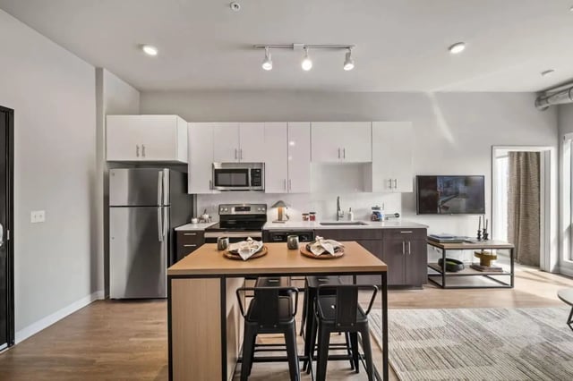 Island with bar stools and appliances kitchen at Proxi Lawrence Apartments in Lawrence Student Accommodation