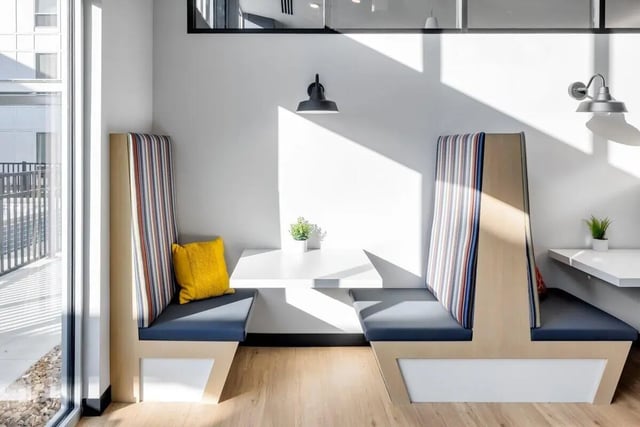 Booth seating yellow pillow small plant communal area at Proxi Lawrence Apartments in Lawrence Student Accommodation