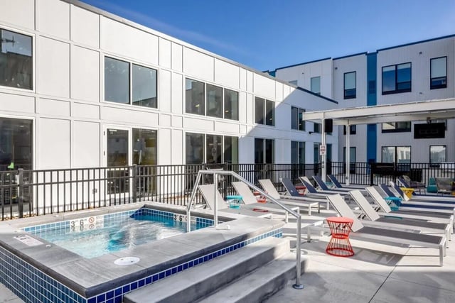 Hot tub lounge chairs and modern buildings exterior at Proxi Lawrence Apartments in Lawrence Student Accommodation