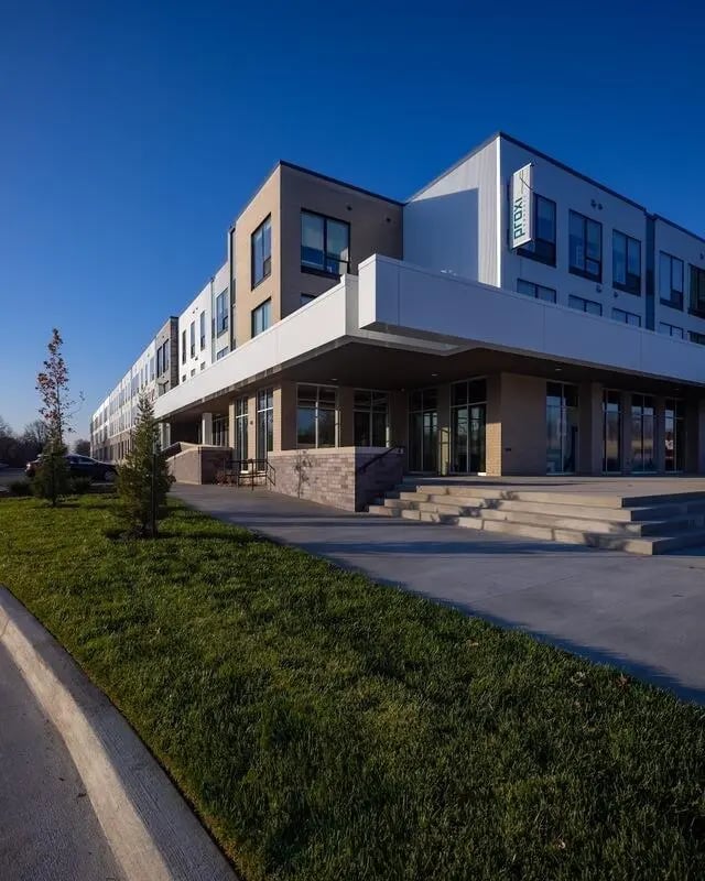 Modern building with glass entrance and stairs exterior at Proxi Lawrence Apartments in Lawrence Student Accommodation