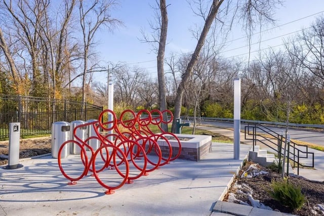 Red bike rack and trash cans exterior at Proxi Lawrence Apartments in Lawrence Student Accommodation