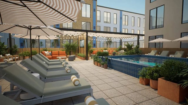 Pool with lounge chairs umbrellas and seating area exterior at Proxi Lawrence Apartments in Lawrence Student Accommodation