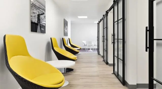 Yellow chairs modern tables sliding glass doors common area at SoCam 290 Apartments in New Brunswick Student Accommodation
