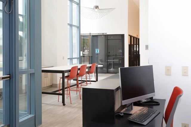 Computer desk with orange chairs communal table study area at SoCam 290 Apartments in New Brunswick Student Accommodation