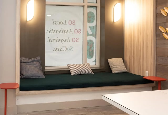 Cushioned bench with pillows by window study area at SoCam 290 Apartments in New Brunswick Student Accommodation