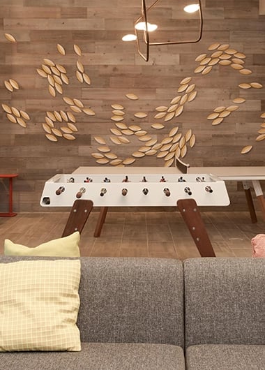 Foosball table on wood wall with sofa living room at SoCam 290 Apartments in New Brunswick Student Accommodation