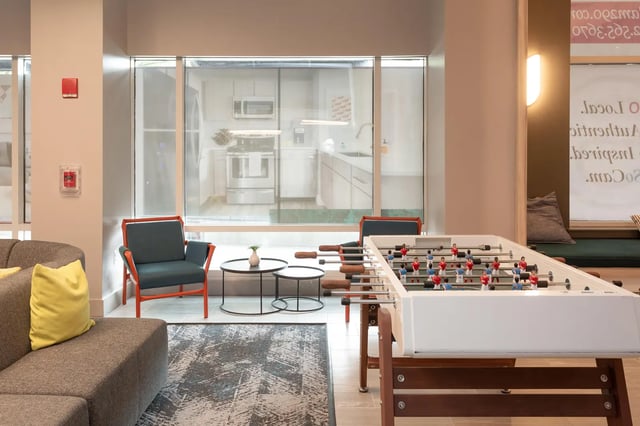 Foosball table chairs and sofa common area at SoCam 290 Apartments in New Brunswick Student Accommodation