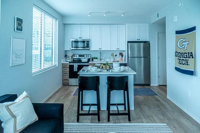 Kitchen island with chairs stainless steel fridge kitchen living room at The Connector Apartments in Atlanta Student Accommodation