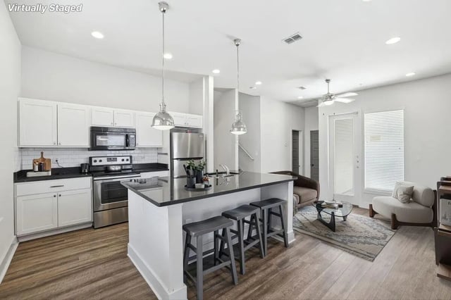 Kitchen island with stools sofa rug living room at The Highlands in Reno Student Accommodation