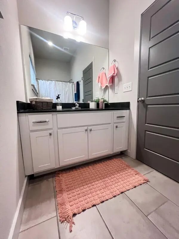 White vanity mirror and pink rug bathroom at The Highlands in Reno Student Accommodation