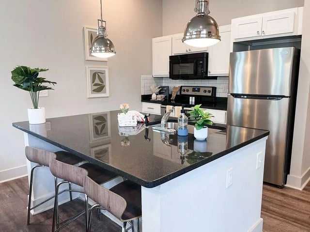 Island with stools sink microwave refrigerator kitchen at The Highlands in Reno Student Accommodation