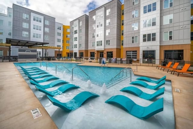 Pool with submerged lounge chairs and fountains exterior at Proximity At 10th in Greenville Student Accommodation