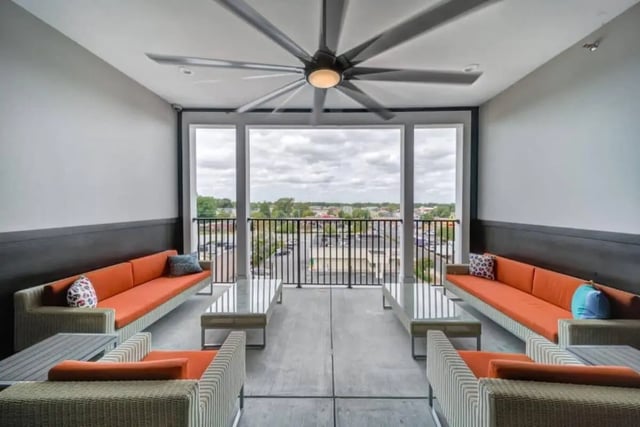 Orange sofas and coffee tables on balcony living area at Proximity At 10th in Greenville Student Accommodation