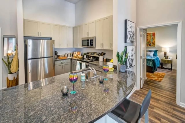 Kitchen counter refrigerator cabinets appliances bedroom interior at Proximity At 10th in Greenville Student Accommodation
