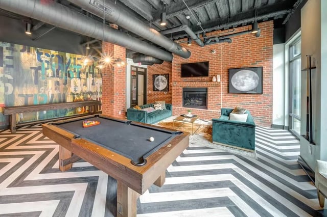Pool table couches fireplace communal area at Proximity At 10th in Greenville Student Accommodation